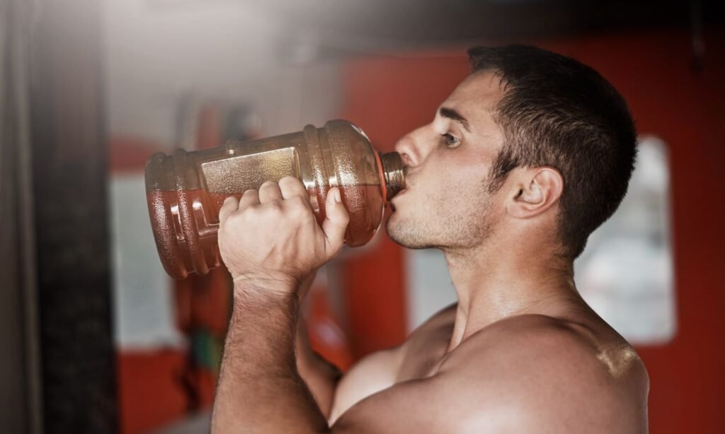 man drinking a pre workout supplement before going to the gym