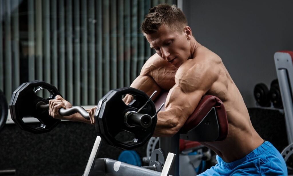 muscular man doing bicep curls and showing a workout pump in arms