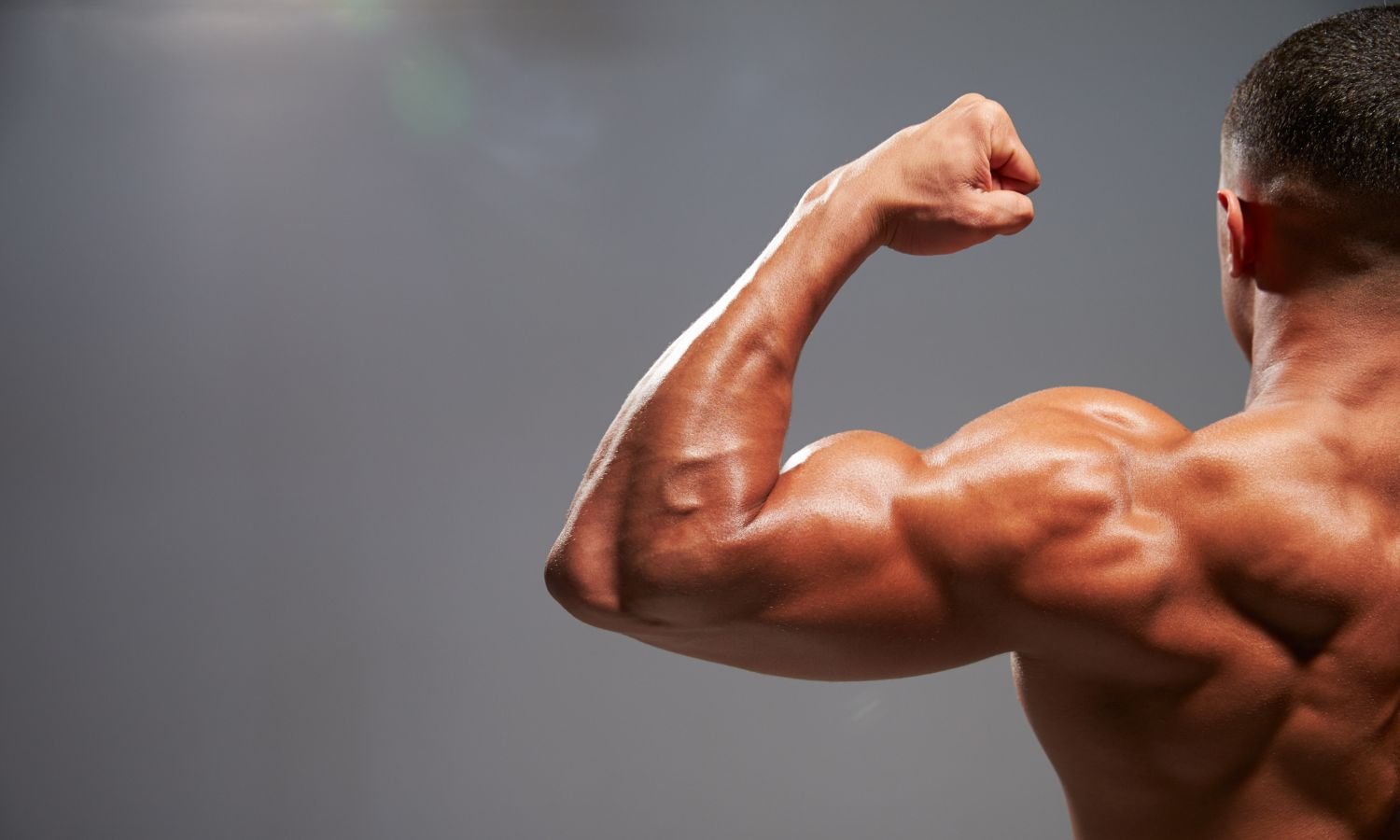 muscular man flexing biceps showing off gym pump in arms